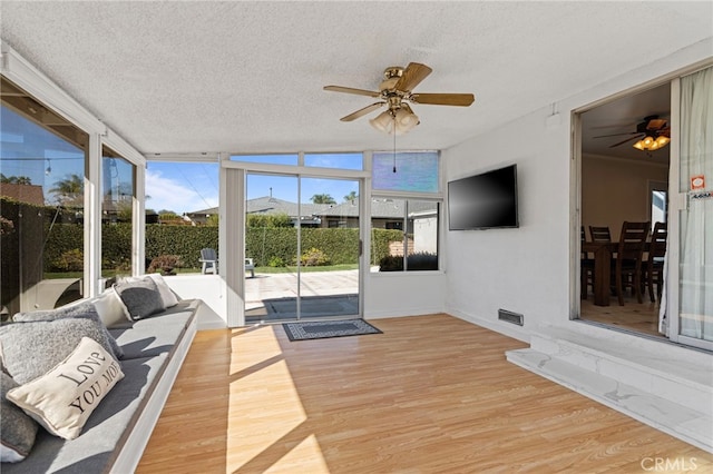 sunroom / solarium with a ceiling fan, visible vents, and plenty of natural light