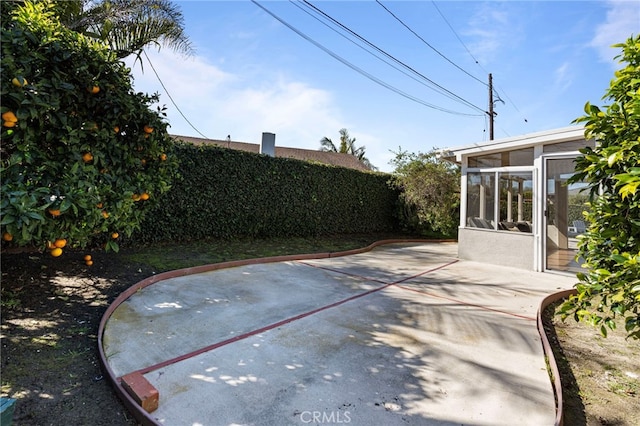 view of patio / terrace with a sunroom and fence