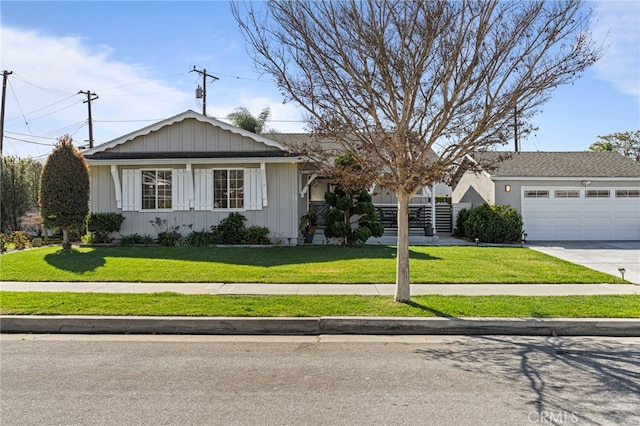 ranch-style house with board and batten siding, a garage, driveway, and a front lawn