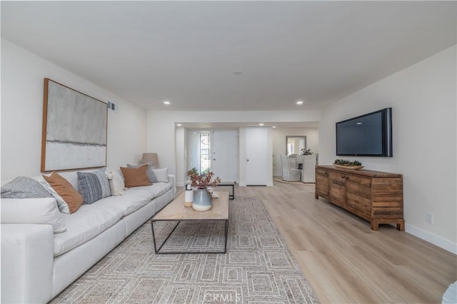 living area featuring baseboards, recessed lighting, visible vents, and light wood-style floors