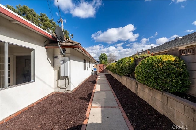 view of home's exterior with fence and stucco siding