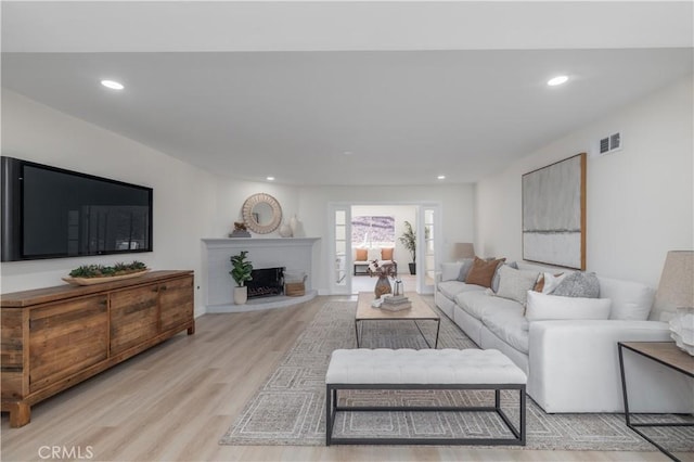 living room with visible vents, wood finished floors, and recessed lighting