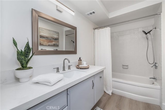 bathroom featuring vanity, shower / bath combo with shower curtain, wood finished floors, and visible vents