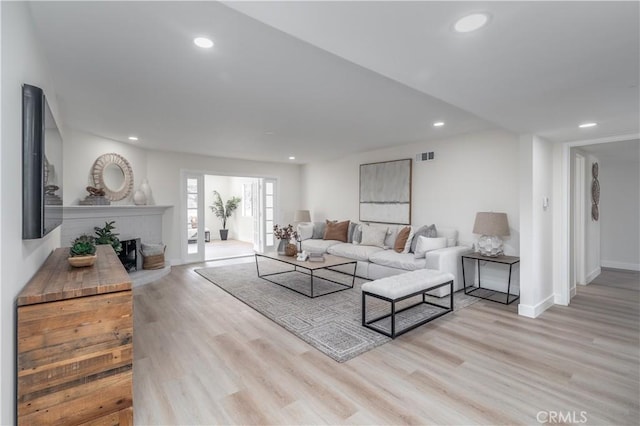 living area featuring baseboards, wood finished floors, visible vents, and recessed lighting