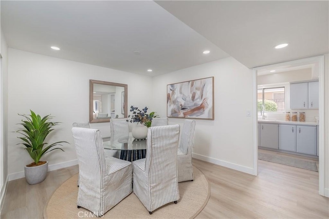 dining area with baseboards, light wood-type flooring, and recessed lighting