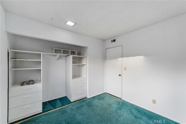 unfurnished bedroom with a closet, visible vents, dark carpet, and a textured ceiling