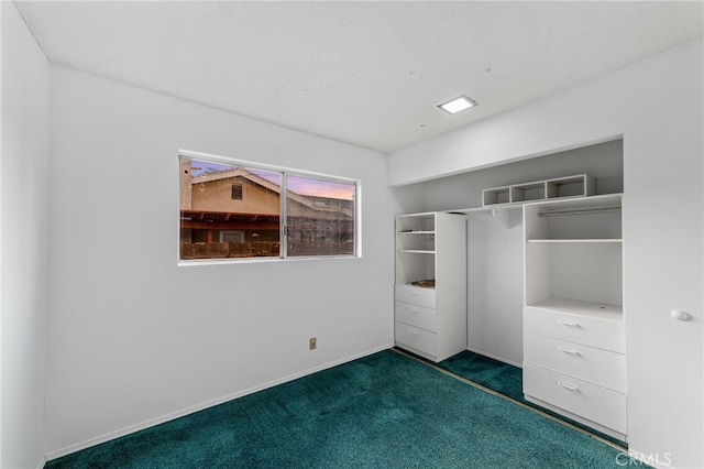 unfurnished bedroom with baseboards, dark carpet, and a closet