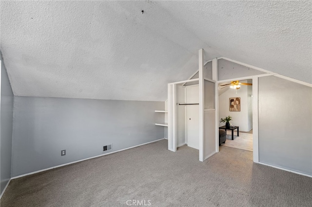 bonus room with visible vents, lofted ceiling, ceiling fan, carpet, and a textured ceiling