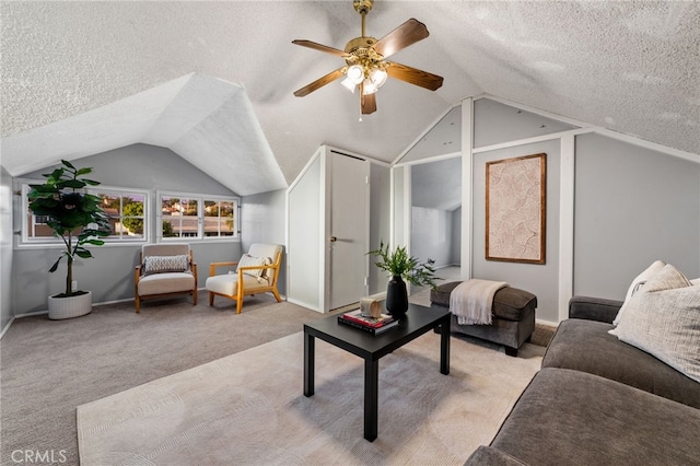 living room featuring lofted ceiling, ceiling fan, a textured ceiling, and light colored carpet