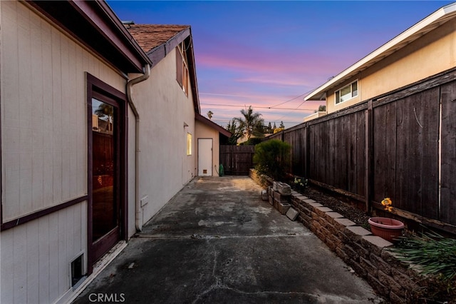 exterior space with a fenced backyard, roof with shingles, and a patio