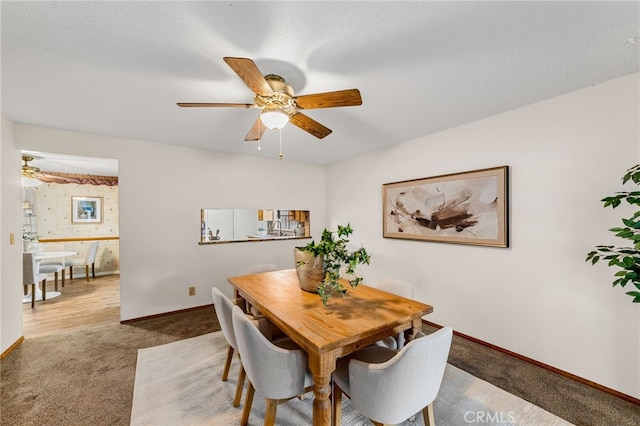 dining space with a textured ceiling, a ceiling fan, baseboards, carpet, and wallpapered walls