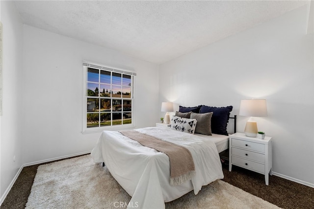 bedroom featuring carpet floors, baseboards, and a textured ceiling