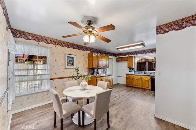 dining room with light wood-type flooring, wallpapered walls, baseboards, and a ceiling fan