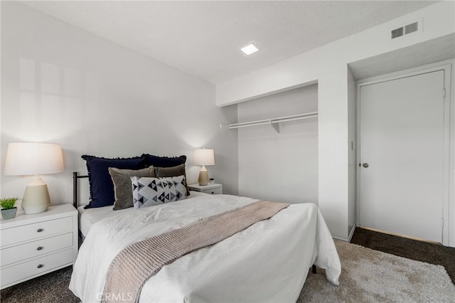 bedroom featuring a closet, visible vents, and dark carpet