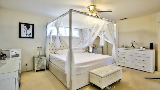 bedroom featuring light colored carpet, ceiling fan, and visible vents