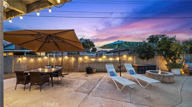 view of patio featuring outdoor dining space, a fire pit, and fence