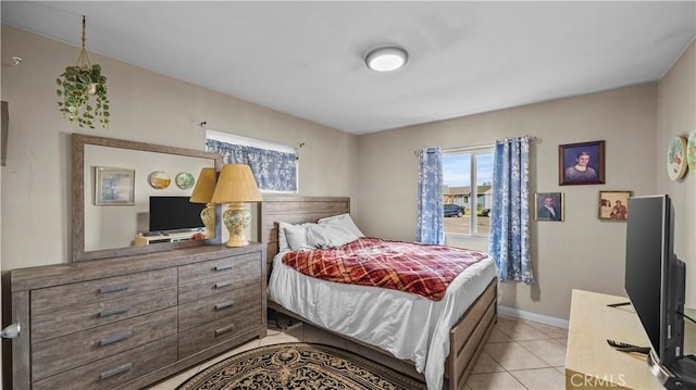 bedroom with light tile patterned floors and baseboards