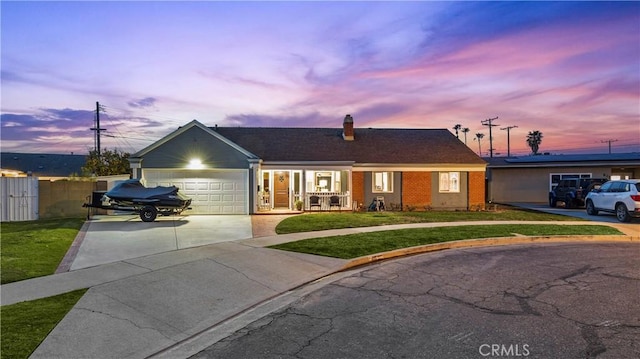 ranch-style house featuring a front yard, an attached garage, brick siding, and driveway