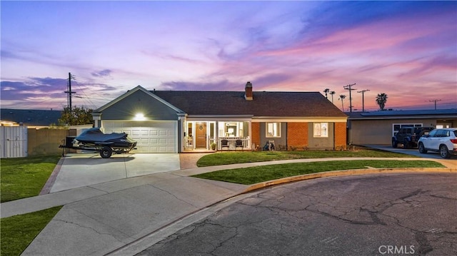 single story home featuring concrete driveway, a lawn, brick siding, and a garage