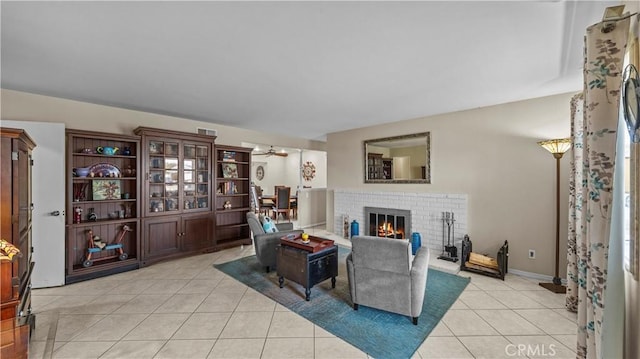 living room featuring light tile patterned flooring, a fireplace, and ceiling fan