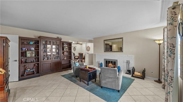 living area with a brick fireplace and light tile patterned floors