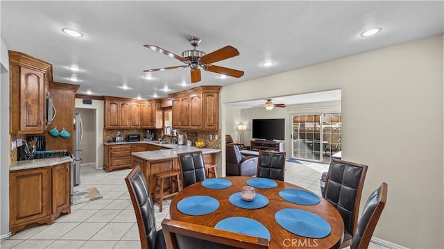 dining area featuring light tile patterned floors, baseboards, a ceiling fan, and recessed lighting