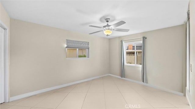 spare room featuring baseboards and a ceiling fan