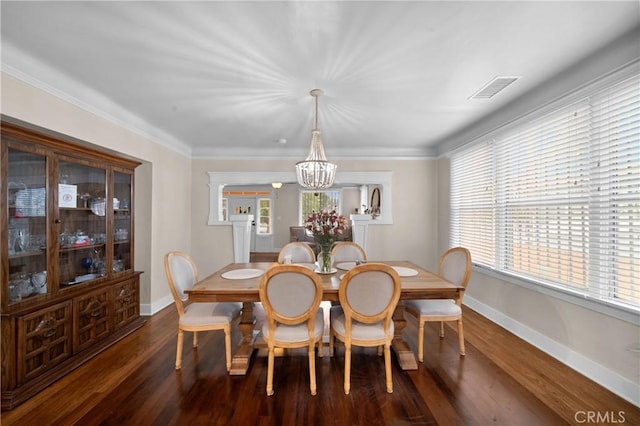 dining area featuring dark wood-style floors, visible vents, crown molding, and baseboards