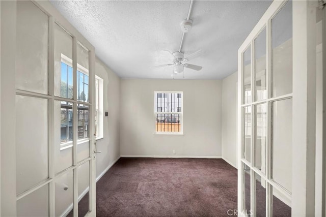 unfurnished room featuring baseboards, a textured ceiling, a ceiling fan, and carpet flooring