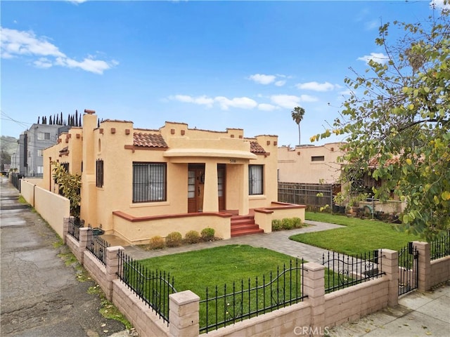 view of front facade featuring a tiled roof, a front lawn, a fenced front yard, and stucco siding