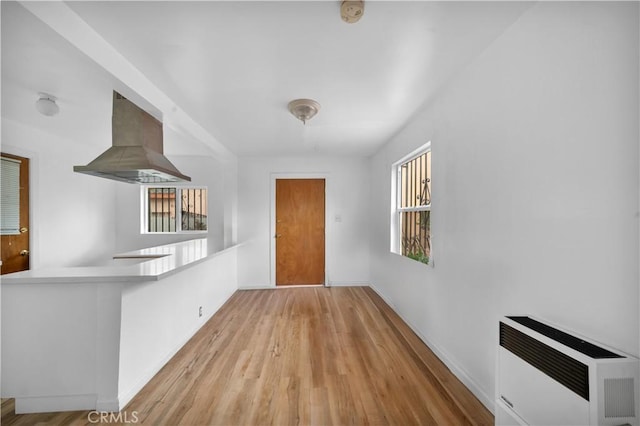 interior space featuring baseboards, heating unit, and wood finished floors