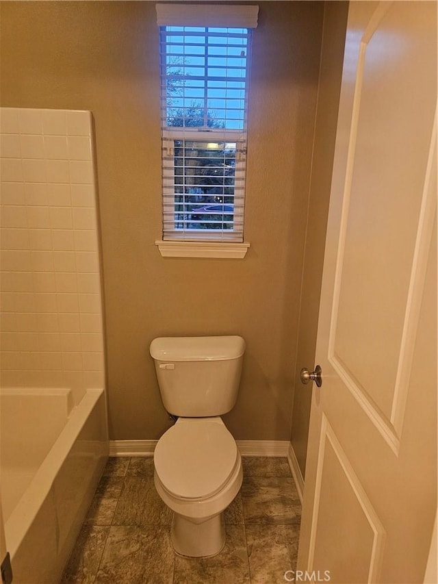 bathroom featuring baseboards and toilet