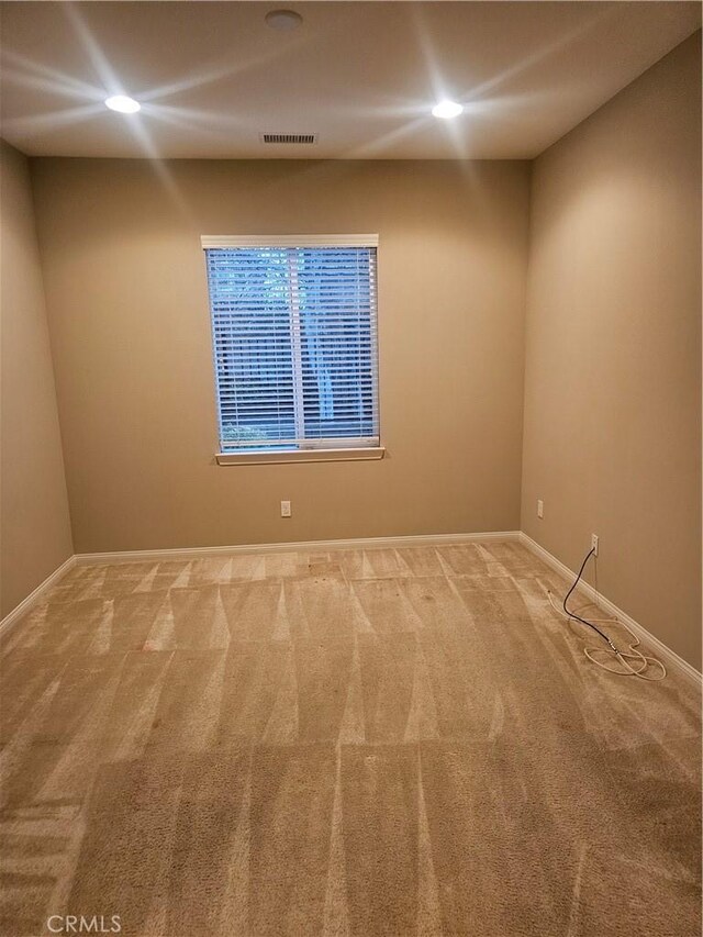 spare room with recessed lighting, visible vents, baseboards, and carpet