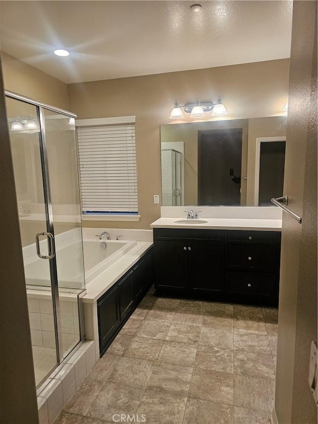 bathroom with a stall shower, vanity, and a bath