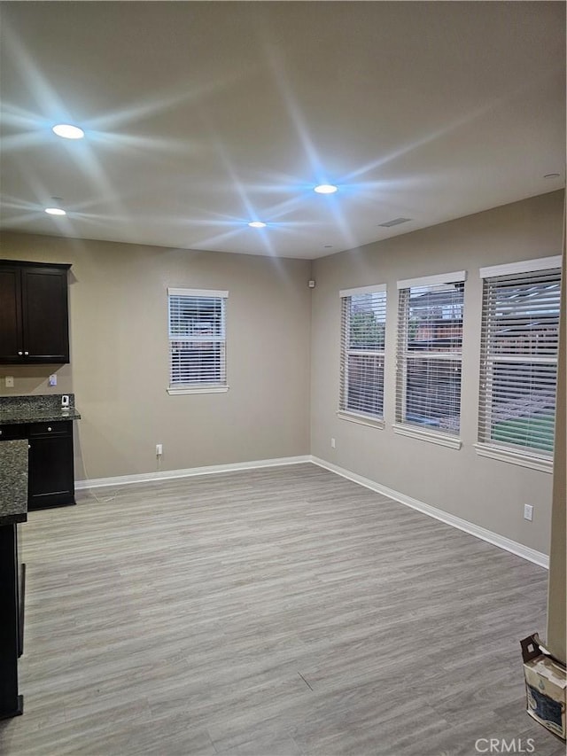 unfurnished living room with recessed lighting, light wood-style floors, and baseboards