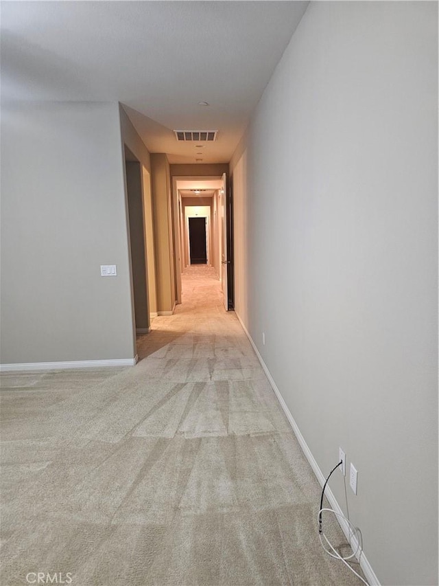 corridor featuring visible vents, baseboards, and carpet flooring