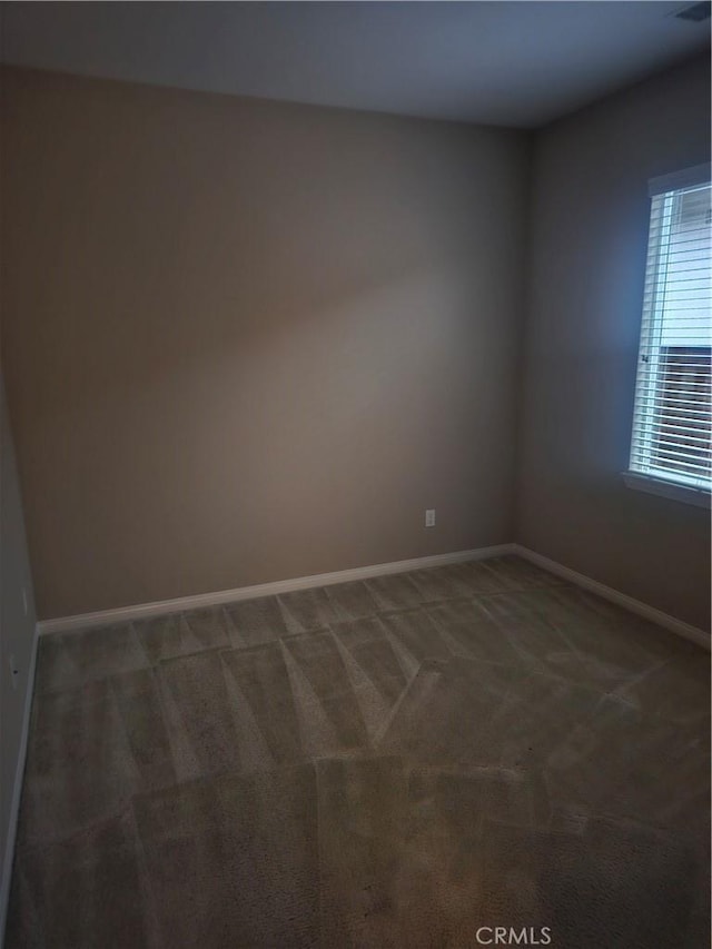 unfurnished room with carpet and baseboards