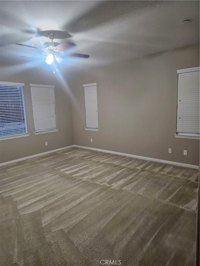 spare room with carpet, baseboards, and ceiling fan