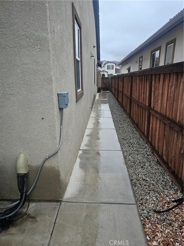 view of property exterior featuring stucco siding and fence