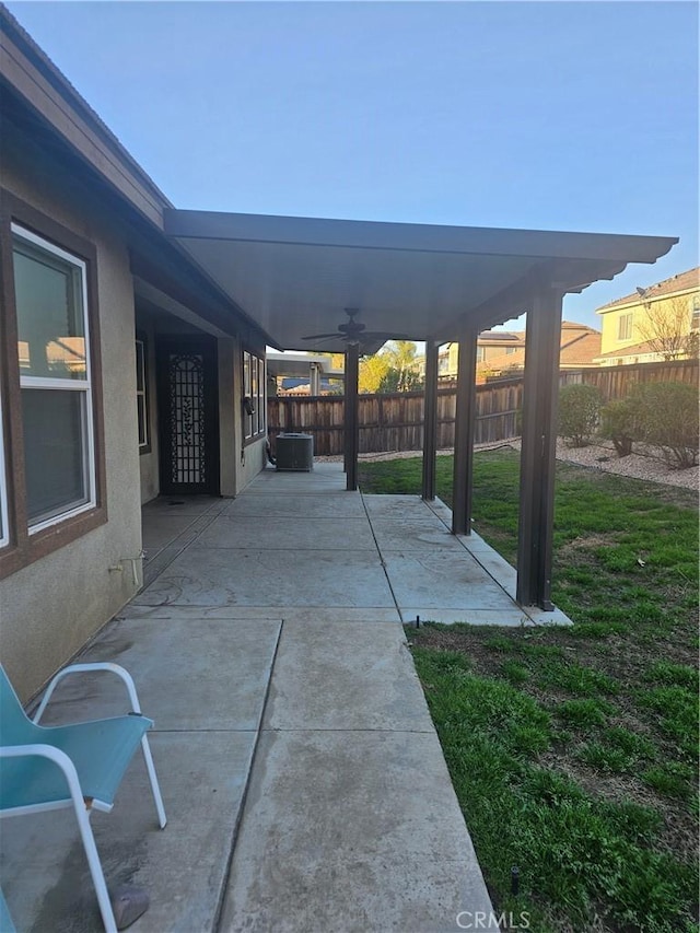 view of patio / terrace featuring central AC unit, ceiling fan, and fence