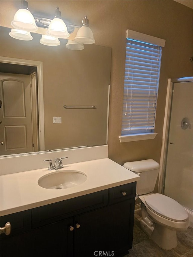 bathroom with vanity, toilet, and a stall shower