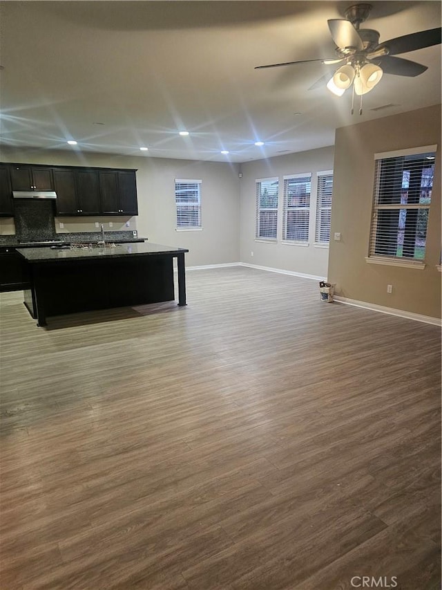 unfurnished living room featuring recessed lighting, ceiling fan, baseboards, and wood finished floors