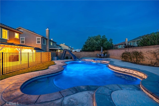 view of pool with a patio, a water slide, a fenced backyard, an in ground hot tub, and a fenced in pool