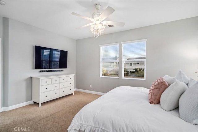 bedroom featuring baseboards, a ceiling fan, and light colored carpet