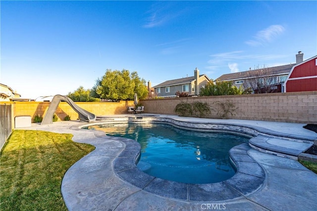 view of swimming pool featuring a fenced in pool, a lawn, a patio area, a water slide, and a fenced backyard