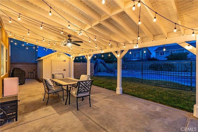 view of patio with outdoor dining space, a fenced backyard, an outbuilding, and a storage unit