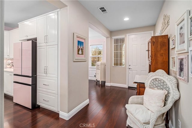 living area featuring dark wood-type flooring, recessed lighting, visible vents, and baseboards