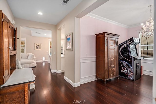 hall featuring baseboards, a notable chandelier, visible vents, and dark wood-type flooring