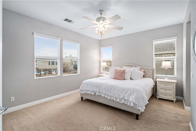 carpeted bedroom featuring baseboards, visible vents, and ceiling fan