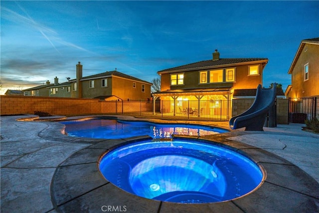 view of pool featuring a patio, a water slide, a fenced backyard, an in ground hot tub, and a fenced in pool